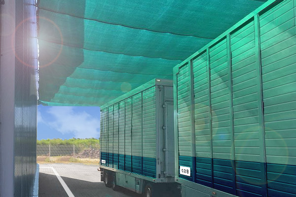 Schattiernetz 140 g/m² - wirtschaftliche Lösung für große Flächen. Schattiernetz 140 g/m² für eine Lkw-Zufahrt horizontal befestigt um das Aufheizen der Ladeflächen bei langen Standzeiten zu reduzieren.