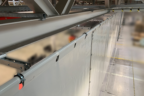 Hallenabtrennung mit Industrievorhang: Wann eine feste Montage sinnvoller ist als ein Schienensystem Hallenabtrennung mit Industrievorhang: Wann eine feste Montage sinnvoller ist als ein Schienensystem