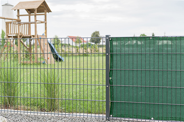 Sichtschutznetz 140 - rundum Ösen alle 40 cm Sichtschutznetz 140 in dunkelgrün am Zaun von einem Spielplatz