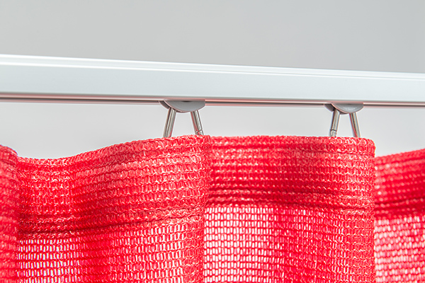 Akzente setzen: Knalliges Rot für individuellen Sonnenschutz nach Maß. Roter Outdoor-Vorhang Fresh im Studio; Darstellung der Faltenbildung und Aufhängung am Vorhangband.