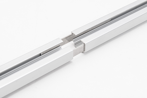 Endlos-Montage: Präzise Schienenverbinder für breite Vorhangfronten. Detail der Aluminium-Steckverbindung für das Fresh-Schienensystem zur Realisierung großer Spannweiten.