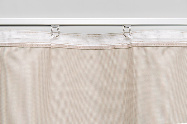 Filigraner Fall und einfache Handhabung durch eine hochwertige Schienenführung. Detailansicht der Schienenbefestigung eines Outdoor-Vorhangs mit speziellen Karabiner-Laufrollen aus Edelstahl.