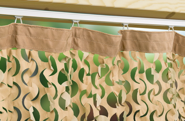 Robuste Aufhängung: Detailansicht des Camouflage-Vorhangs mit Laufrollen-System und Vorhangschiene. Nahaufnahme eines beige-hellbeigen Outdoor-Vorhangs Camouflage nach Maß mit Laufrollen in einer stabilen Vorhangschiene am Holzbalken.